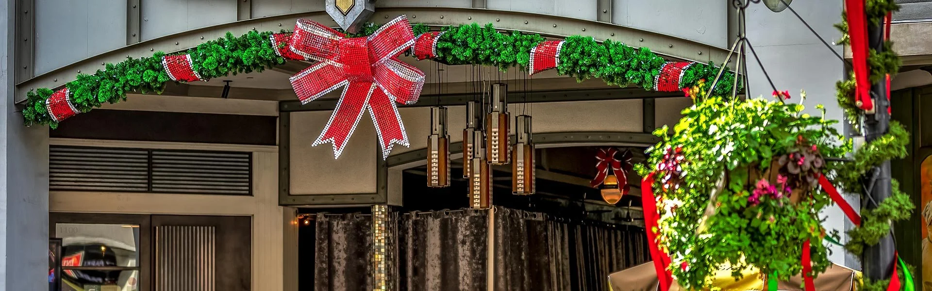Red bow and garland over a storefront at Santana Row