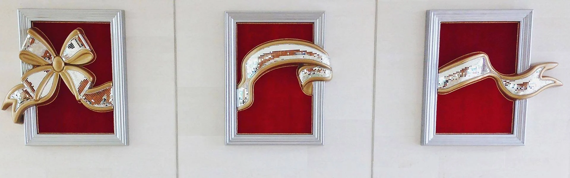 Gold ribbon and bow wall decor in red frames at Wells Fargo