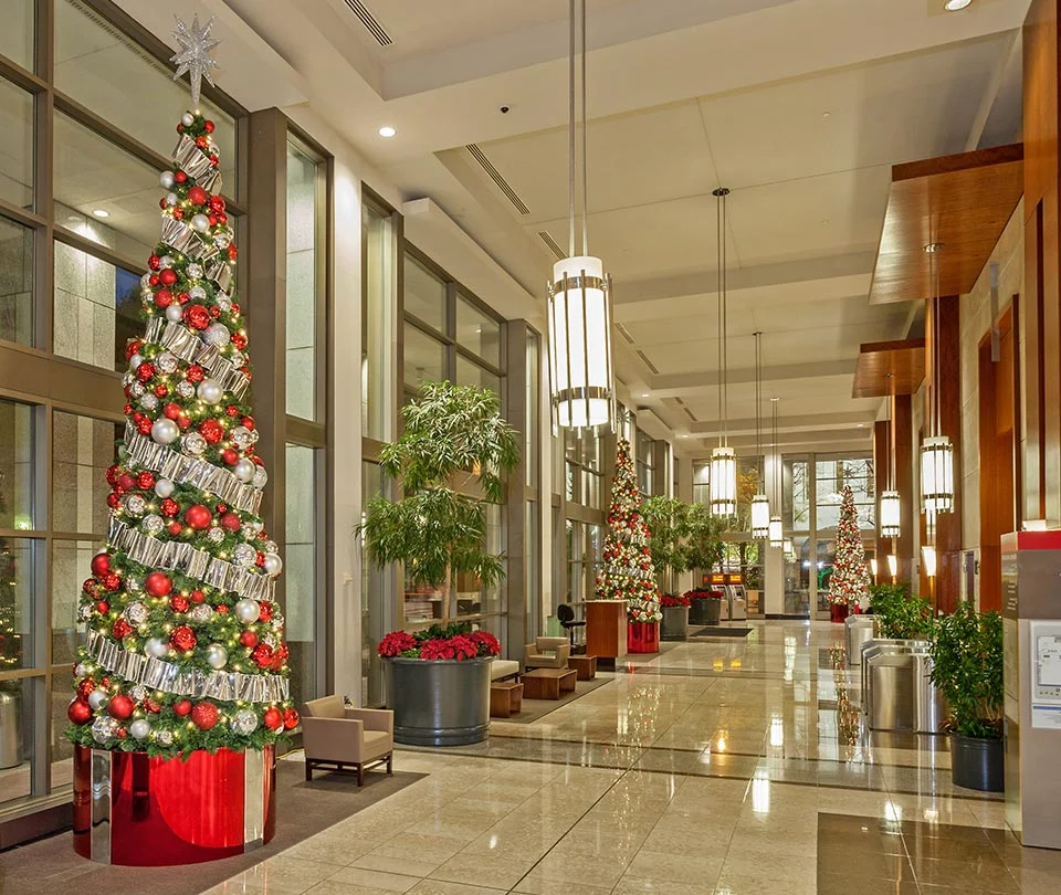 Tall Christmas tree with red and silver ornaments in a Wells Fargo lobby