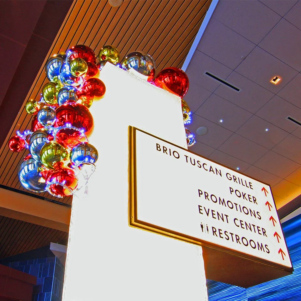 Cluster of colorful ornaments on a casino directional sign