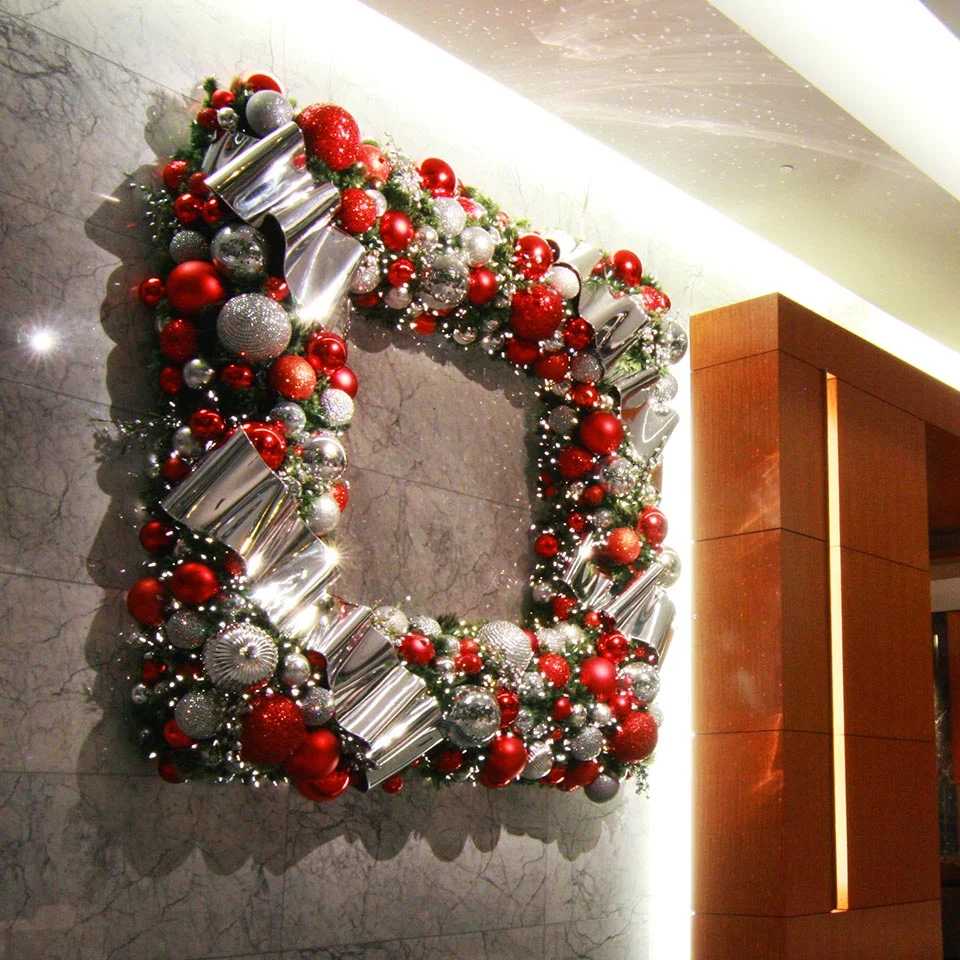 Large square wreath of red and silver ornaments on a lobby wall